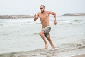 man-jogging-shirtless-beach-awaken