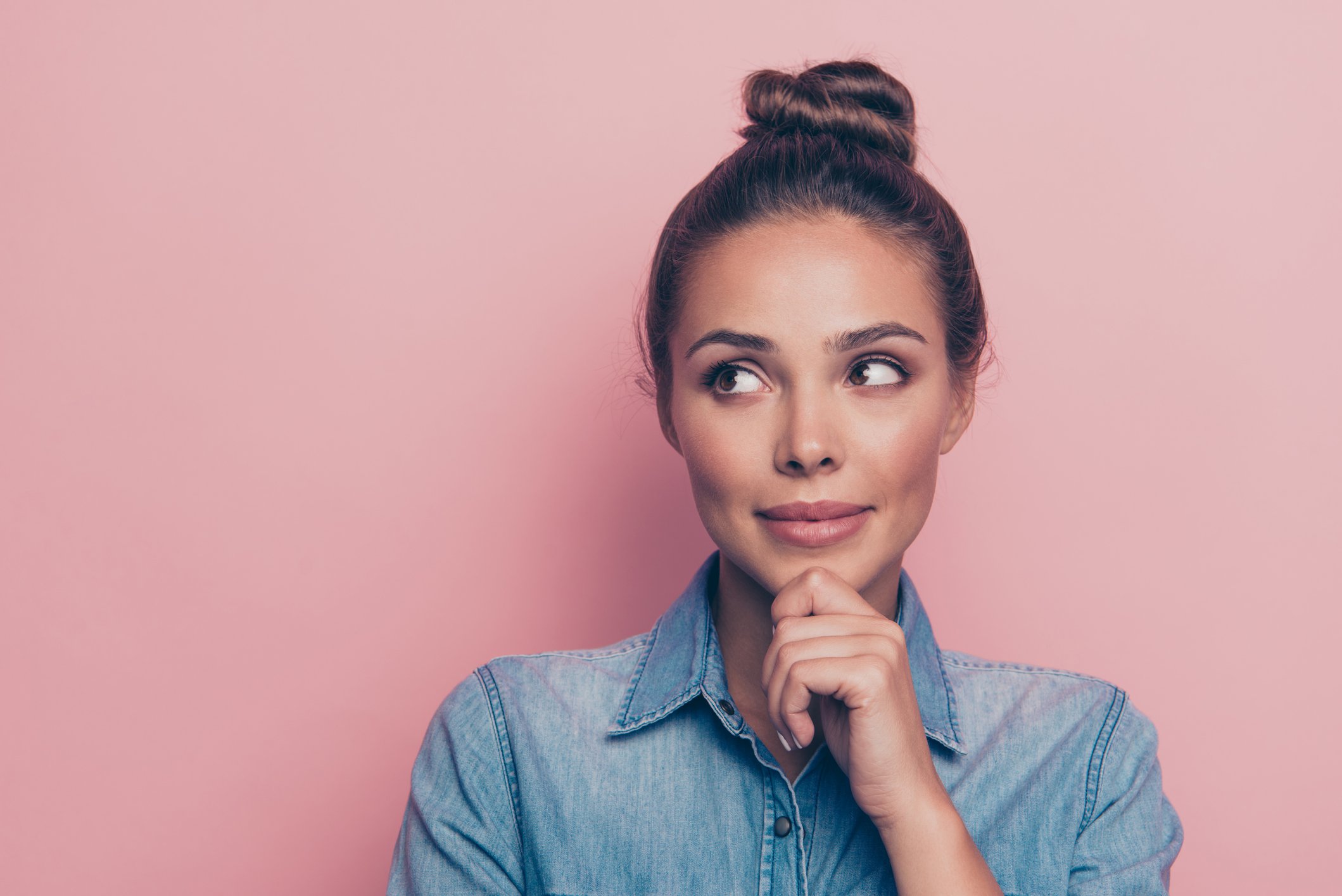 Portrait of curious woman on pink background