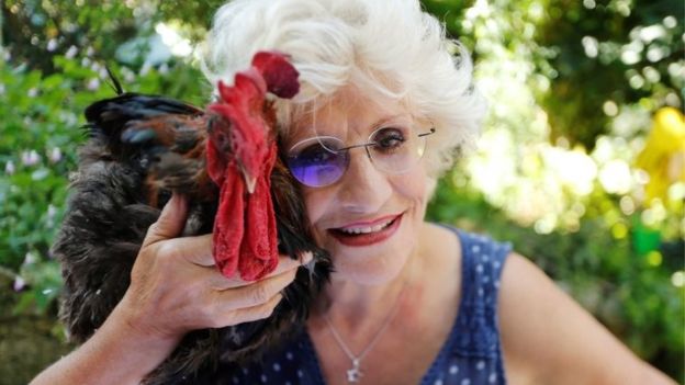 Corinne Fesseau poses with her rooster Maurice