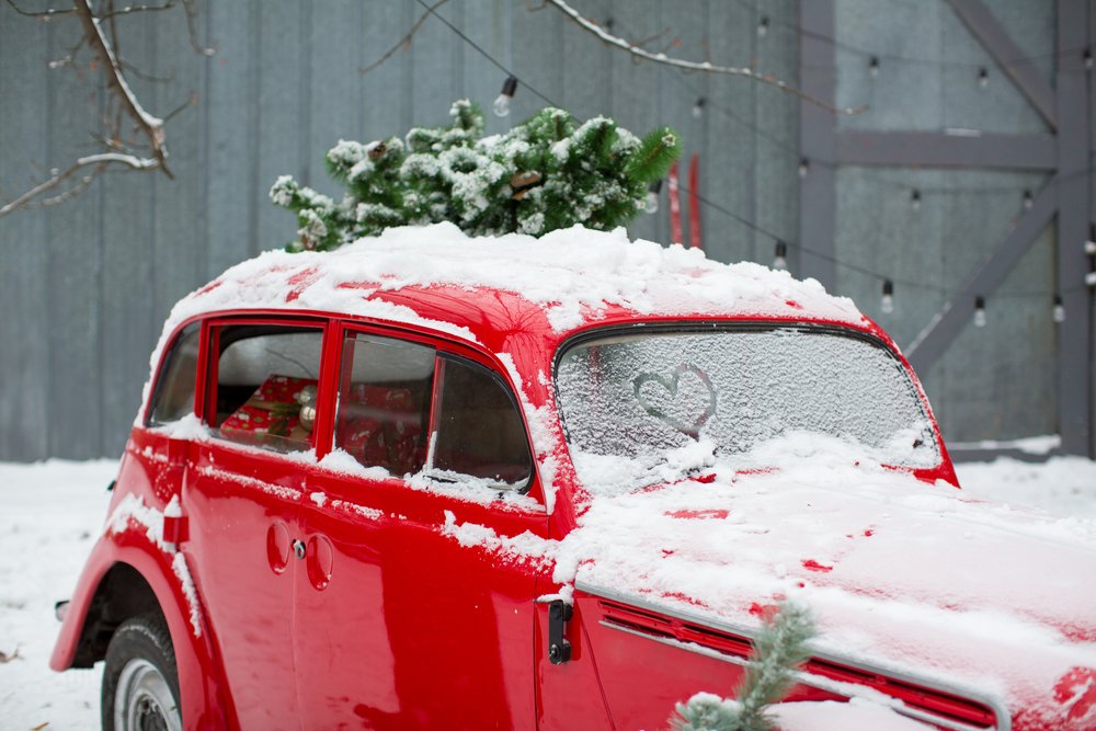 red retro car with a Christmas tree on top and presents