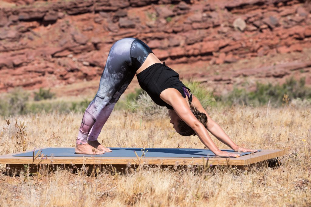 woman practicies downward facing dog pose