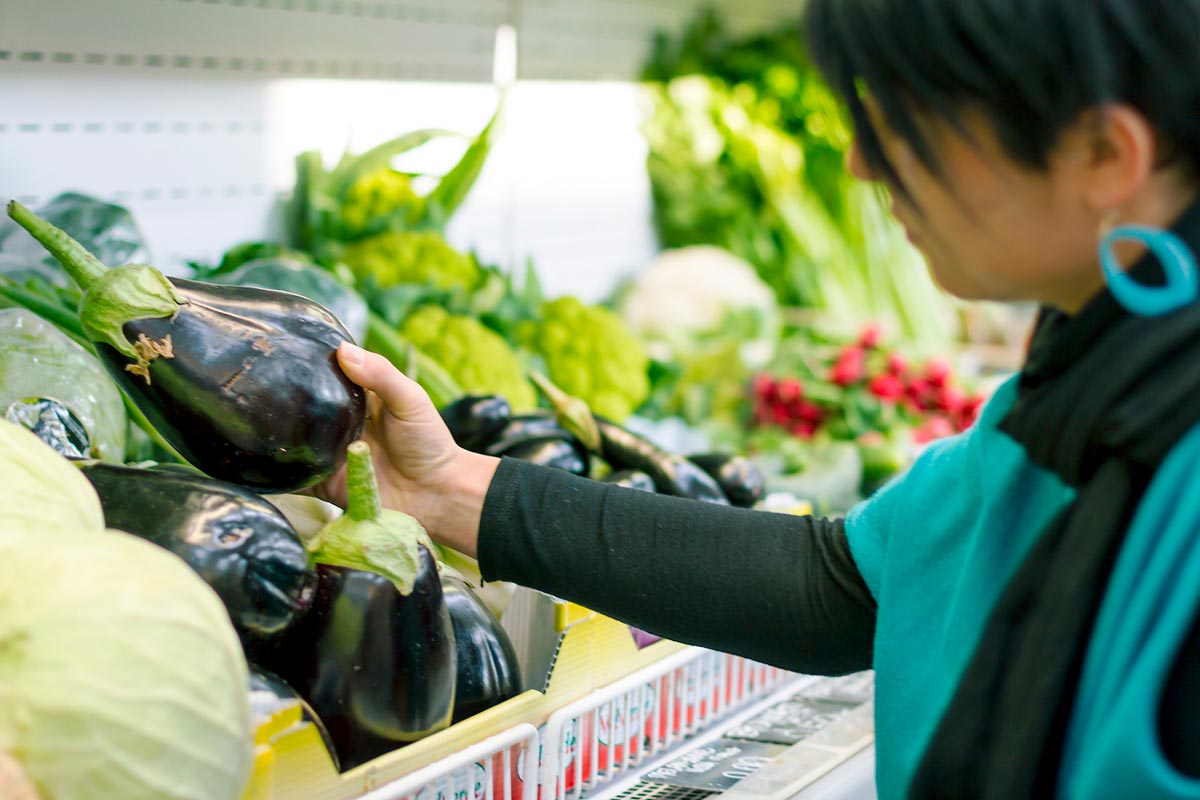 woman choosing eggplants