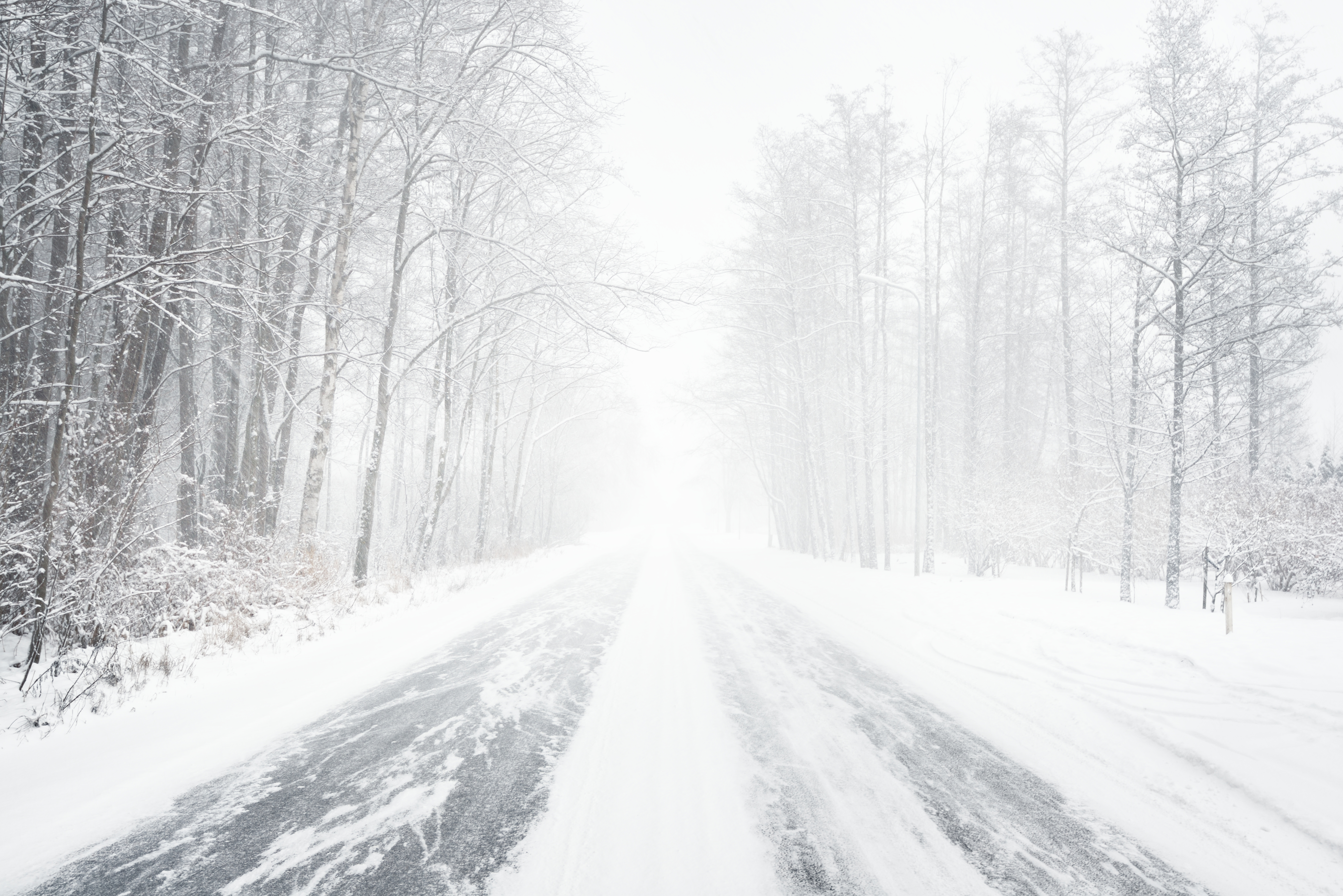 Snowy winter road during blizzard in Latvia. Heavy snow storm.