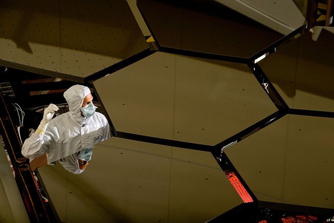 A technician inspects the mirror panels of the James Webb Space Telescope