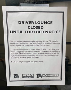 A sign at the Johnson's Corner truck stop says the driver lounge is closed because of the coronavirus outbreak. Drivers can usually relax and watch TV on lounge chairs at the stop during mandatory rest periods.