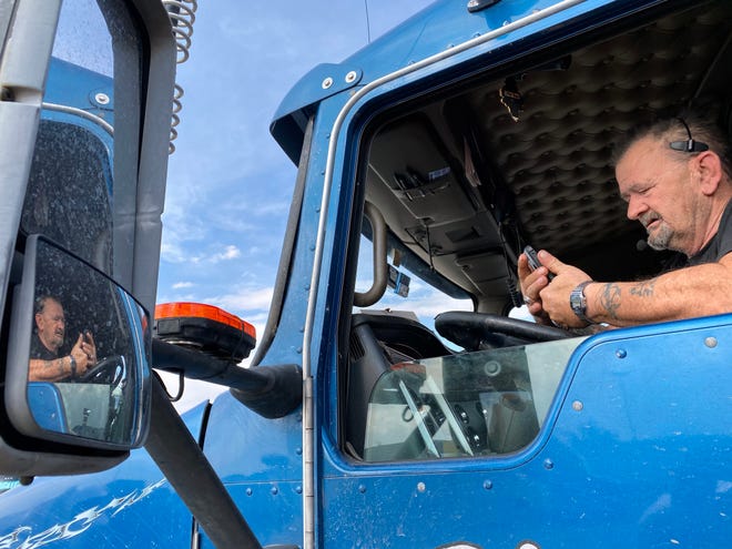 Trucker Ron Applegate, 57, looks at his phone while talking to his wife while parked at the Johnson's Corner truck stop between Denver and Cheyenne.