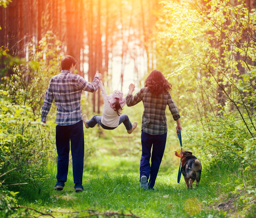 parents and kid and dog in nature