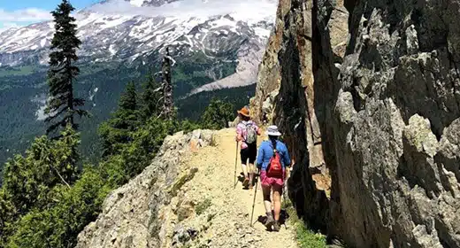 Two hikers traverse a narrow trail-awaken