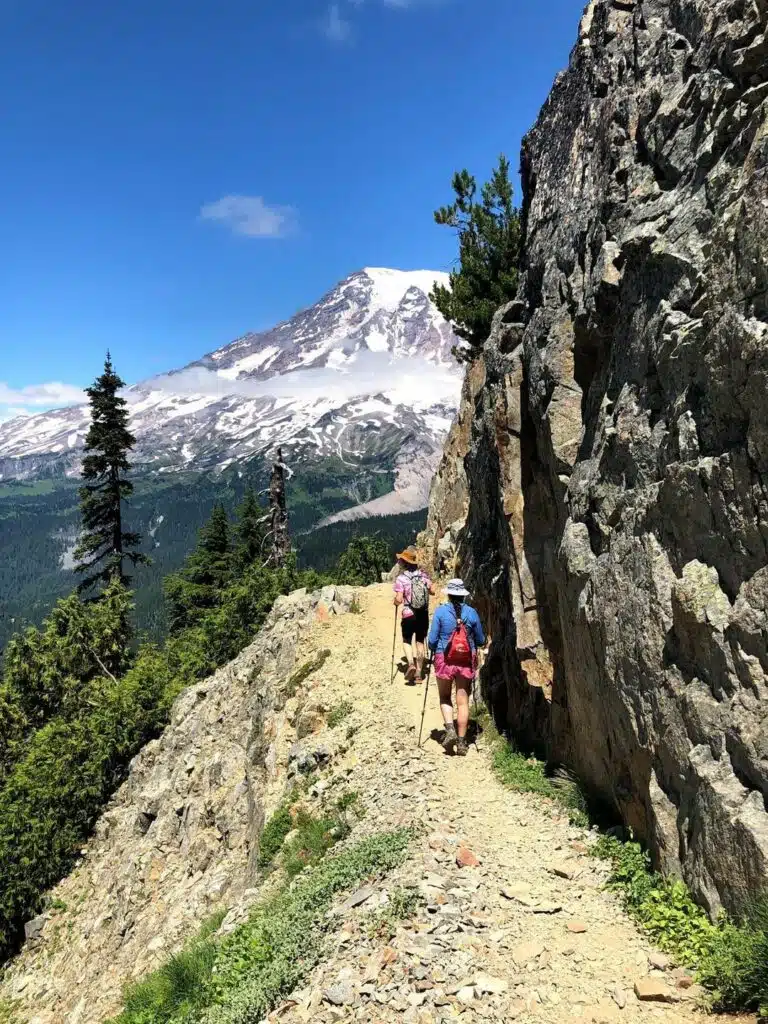 Two hikers traverse a narrow trail -awaken